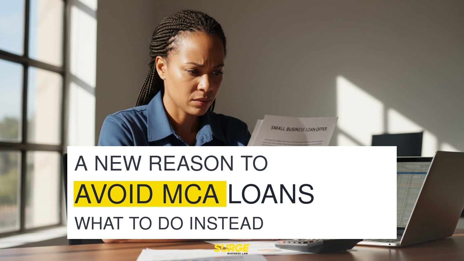 Worried business owner reviewing a merchant cash advance loan agreement at a desk